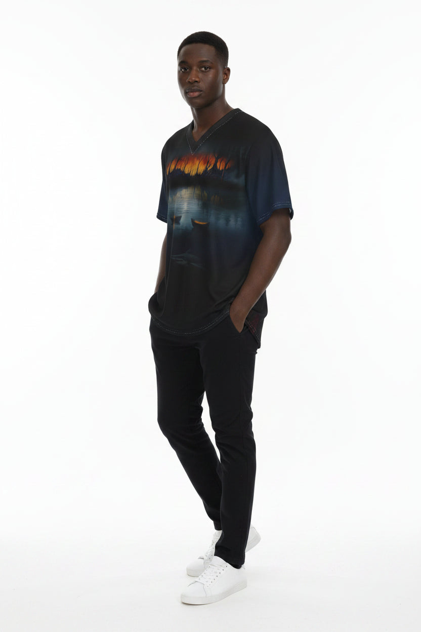A short-sleeve V-neck athletic jersey with an all-over scenic print of a lake at dusk, featuring a fiery orange and yellow sunset along the shoreline, silhouetted trees, reflections on the water, and a fish jumping near the bottom.
