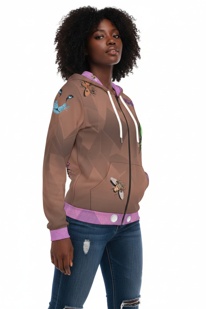 A woman modeling a brown zip-up hoodie with a geometric pattern, purple trim, and insect graphics, paired with distressed blue jeans against a plain white background.