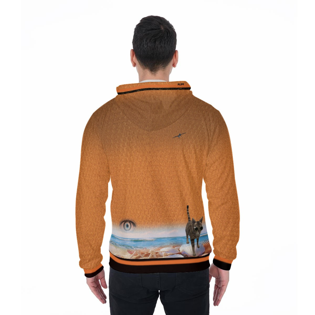 A man viewed from the back wearing a textured orange hoodie with a graphic print on the lower back showing a cat on a beach and a large eye, set against a plain white background.