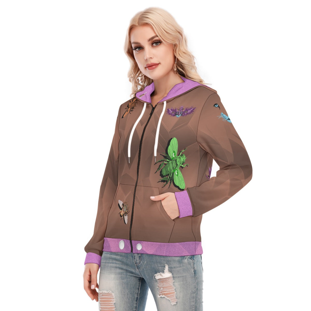 A woman modeling a brown zip-up hoodie with purple trim, white drawstrings, and insect graphics, paired with distressed blue jeans against a plain white background.