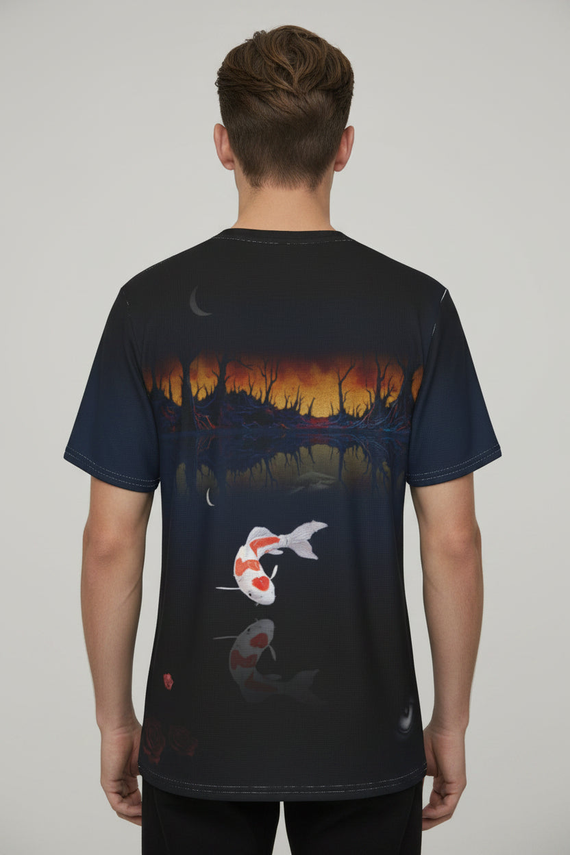 A short-sleeve t-shirt shown from the back, featuring a dark navy and black background with a detailed graphic print of a koi fish in a pond at sunset, complete with a reflection.