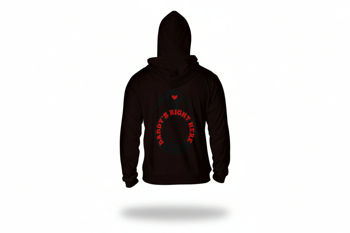 A man viewed from the back wearing a black hoodie with a red graphic on the back. The graphic features a small red heart above a ring outline with the text 'DADDY'S RIGHT HERE' in red.