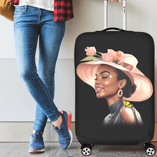 Person holding a suitcase with a design of a woman wearing a hat and flowers, standing against a neutral background.